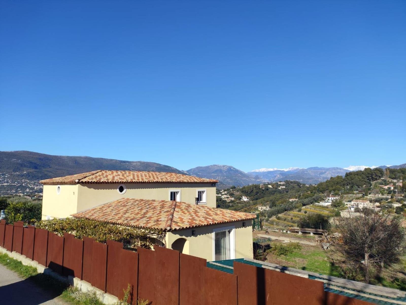 La maison du gîte et la vue sur les collines jusqu'aux sommets du Mercantour